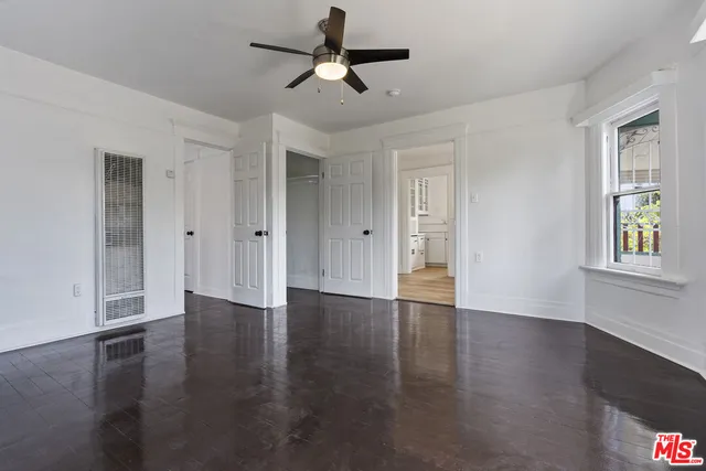 an empty room with a window and a ceiling fan