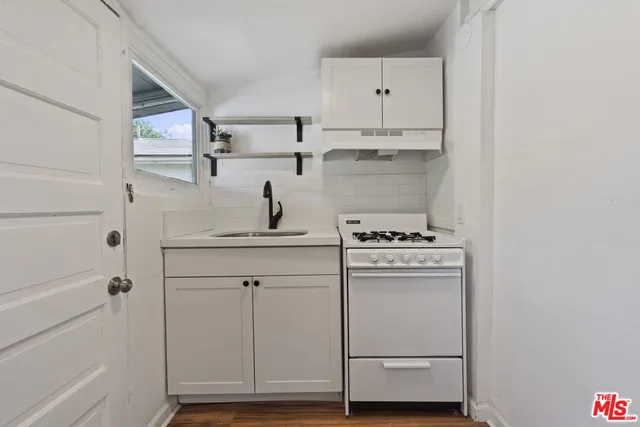 a view of a room with wooden floor cabinet and a bathroom