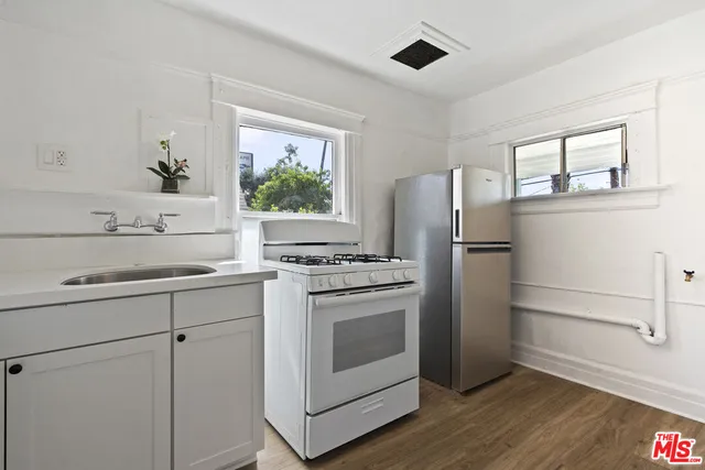 a kitchen with white cabinets and white appliances