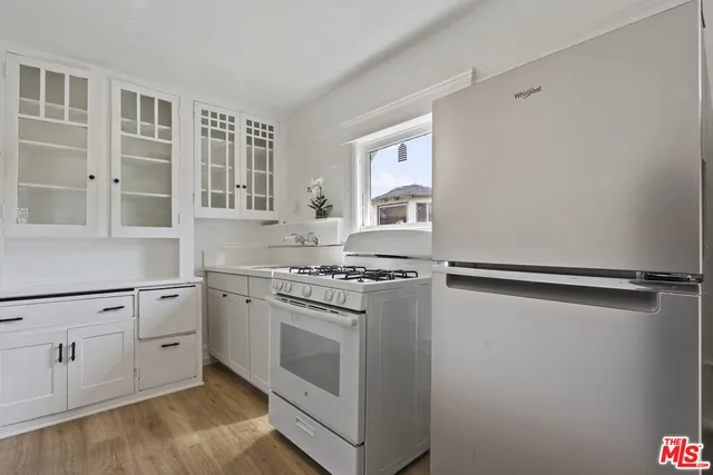 a kitchen with white cabinets and white appliances