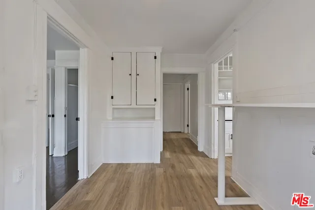an empty room with wooden floor chandelier fan and windows