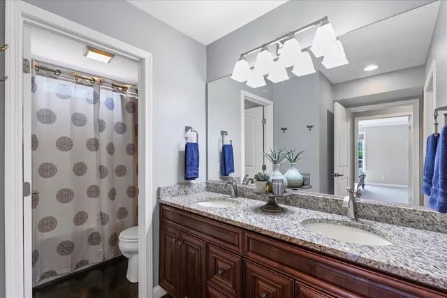 a bathroom with a granite countertop sink a large mirror and a shower