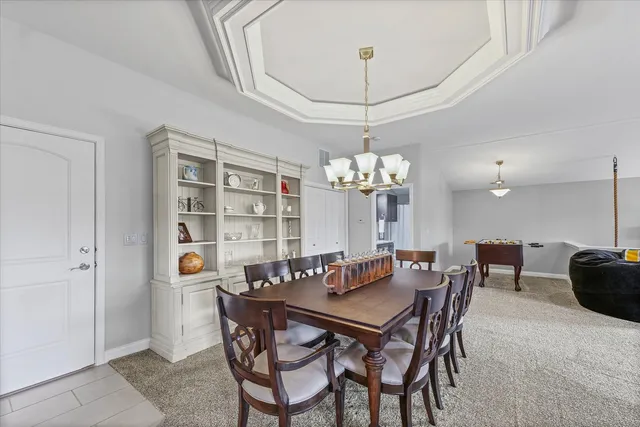 a view of a dining room with furniture and chandelier