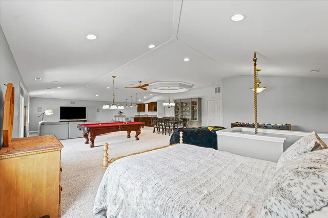 a bedroom with a bed and a large mirror with a couch