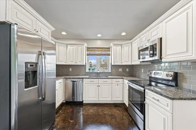a kitchen with stainless steel appliances granite countertop a refrigerator sink and cabinets