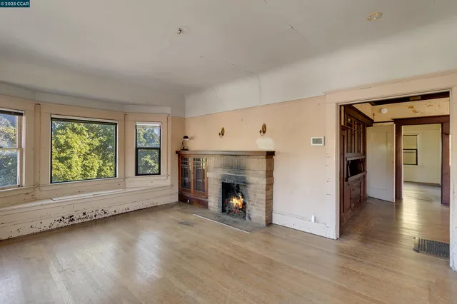 a view of an empty room with window and fire place