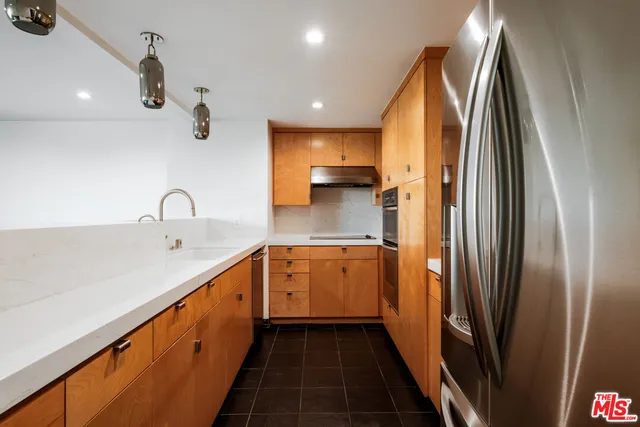 a kitchen with stainless steel appliances a sink and a refrigerator
