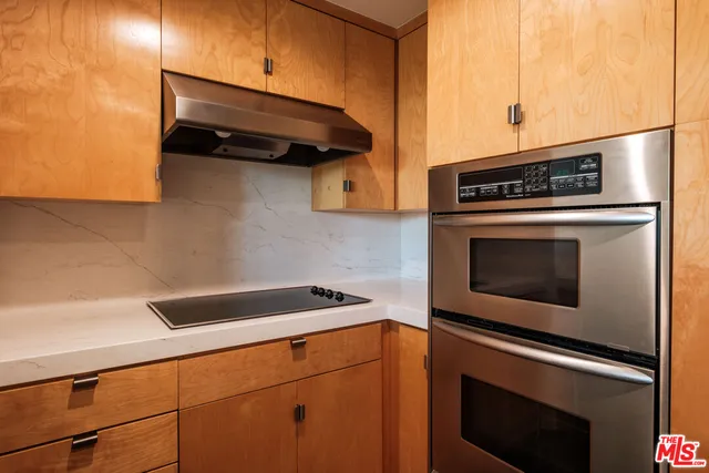 a kitchen with granite countertop cabinets stainless steel appliances and wooden floor
