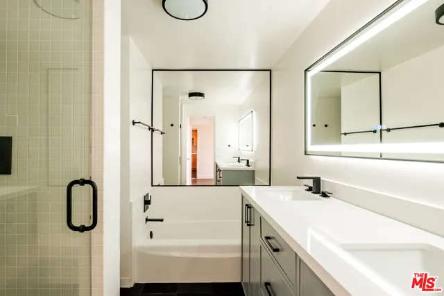a bathroom with a tub sink and mirror