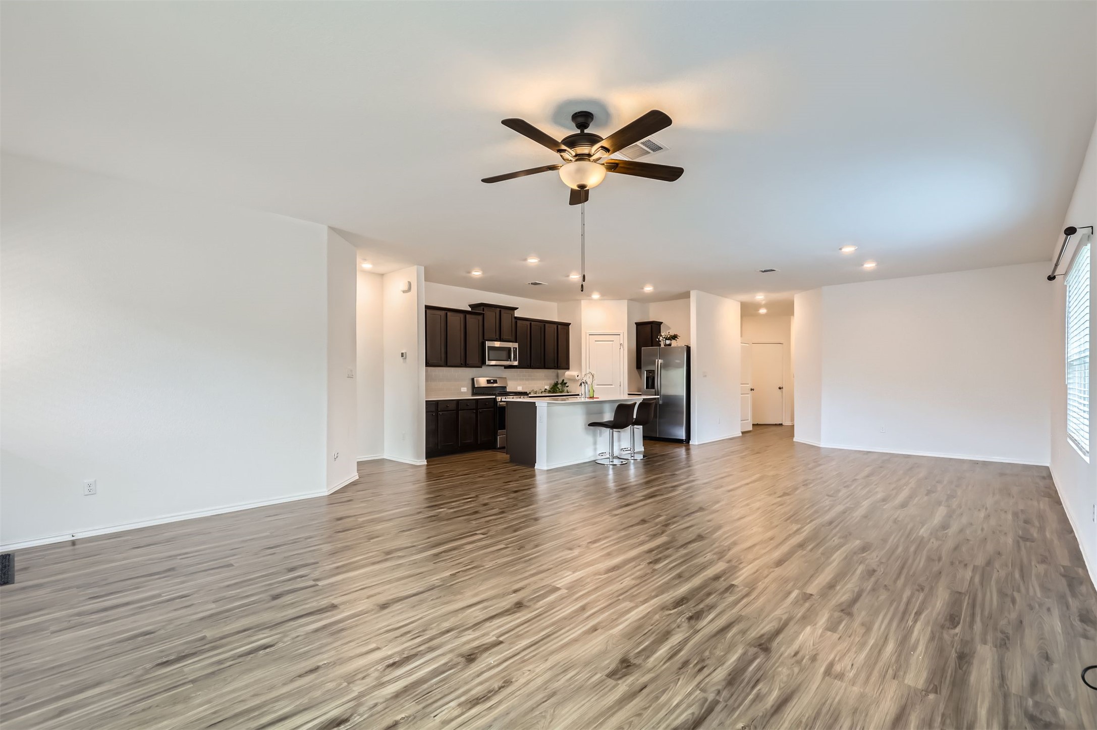 1632 Woolsey Way Leander, TX 78641 - Photo 4 of 29 Vinyl plank flooring spreads across this large space.