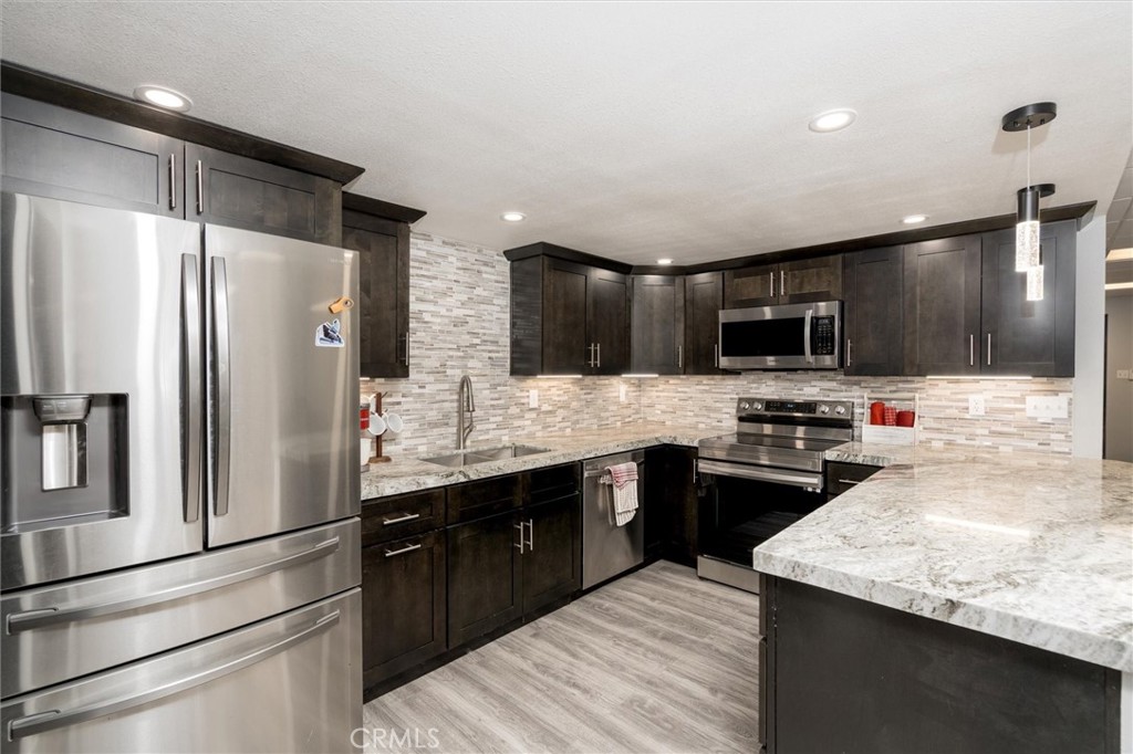 34150 Stowe Road Winchester, CA 92545 - Photo 53 of 80 a kitchen with stainless steel appliances kitchen island granite countertop a refrigerator stove microwave and sink