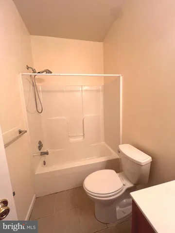 a white toilet sitting next to a bath tub and a shower