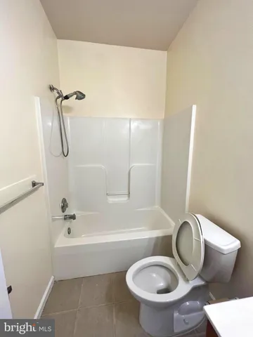 a bathroom with a granite countertop toilet and a sink