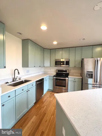 a kitchen with cabinets a sink and stainless steel appliances