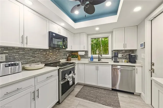 a kitchen with a stove sink cabinets and window