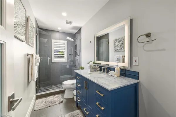 a bathroom with a granite countertop sink toilet and shower