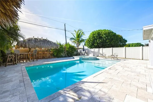 a view of a swimming pool with a patio and a yard