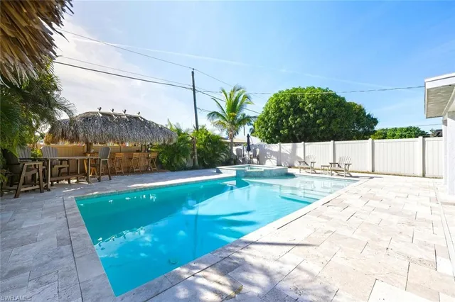 a view of a swimming pool with a patio and a yard