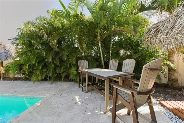 a view of a house with pool fire pit and chairs in front of it