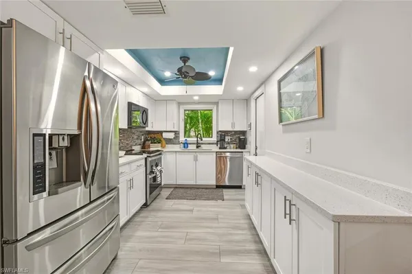 a kitchen with white cabinets and stainless steel appliances