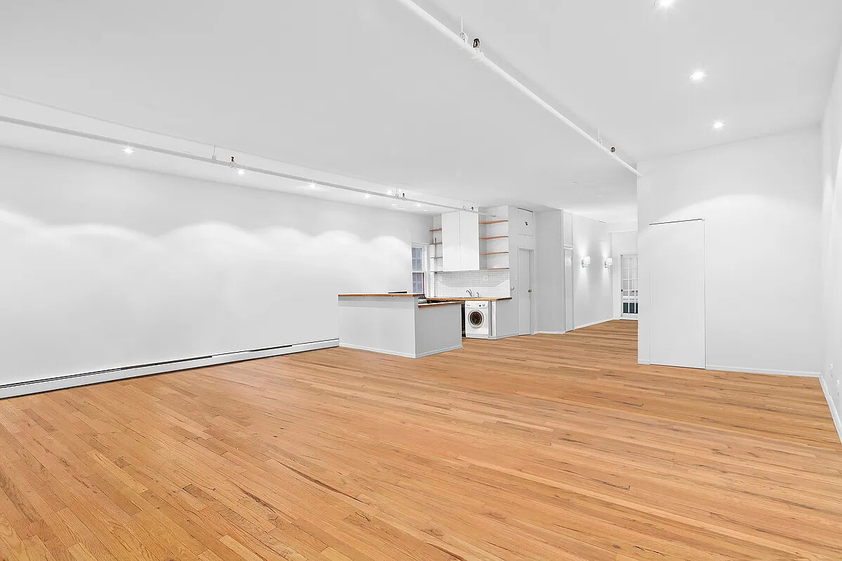 471 Broadway, Unit 3 Manhattan, NY 10013 - Photo 2 of 10 a view of a kitchen with wooden floor and a ceiling fan
