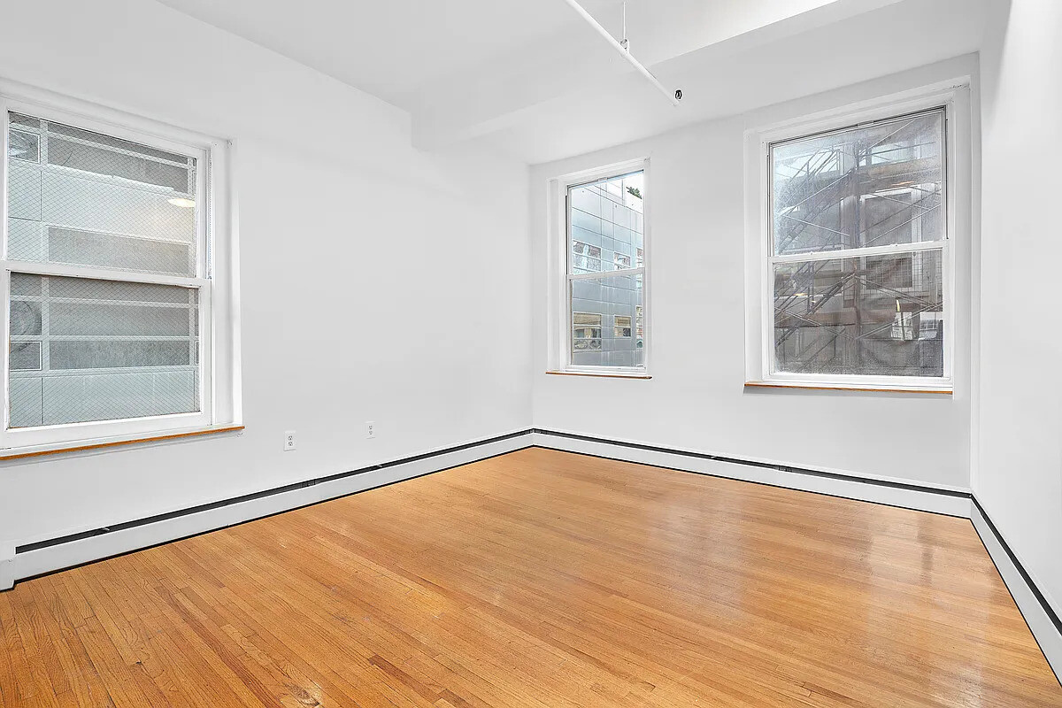 471 Broadway, Unit 3 Manhattan, NY 10013 - Photo 6 of 10 a view of an empty room with a window and wooden floor