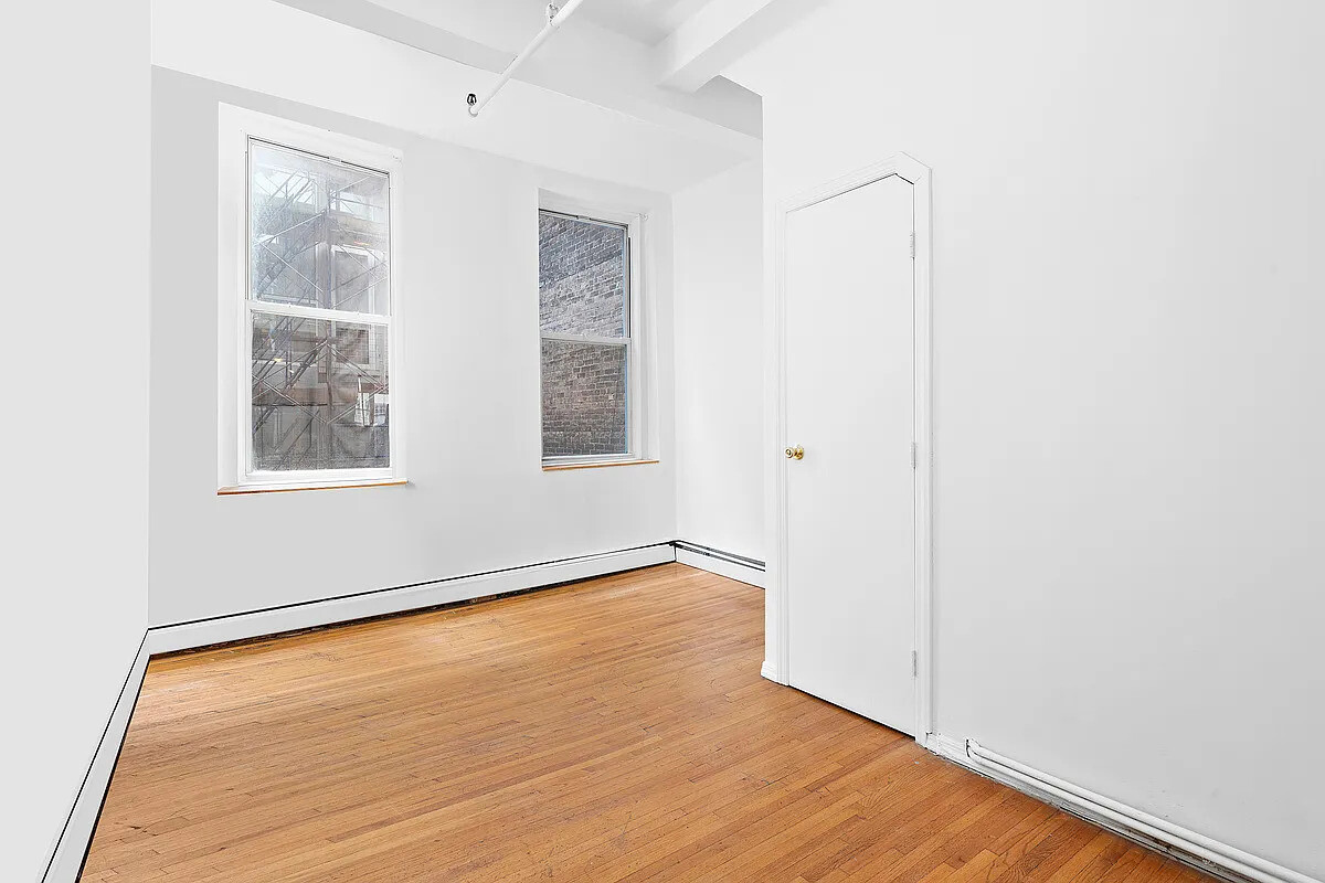 471 Broadway, Unit 3 Manhattan, NY 10013 - Photo 8 of 10 an empty room with wooden floor and windows