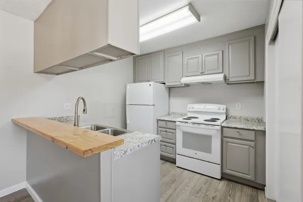 a kitchen with a sink a stove and cabinets