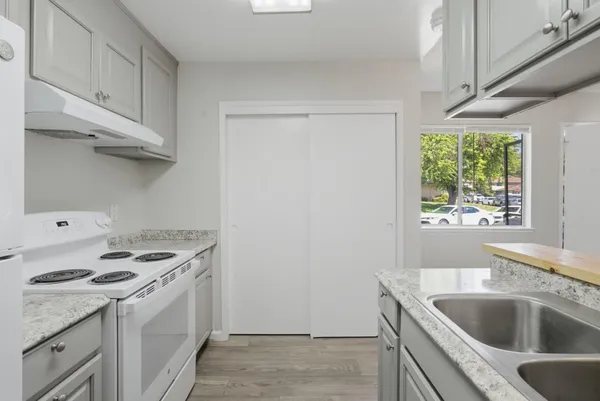 a kitchen with granite countertop a sink stove and refrigerator