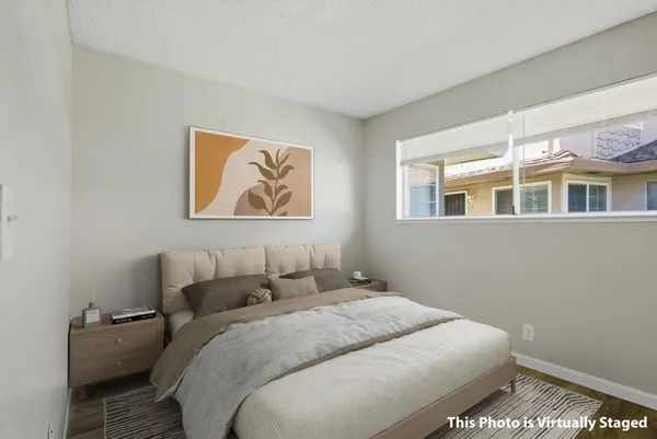 a bedroom with a bed and a painting on the wall