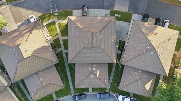an aerial view of a house with a yard and a wooden fence