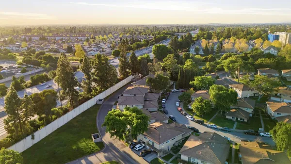 an aerial view of multiple houses with a yard