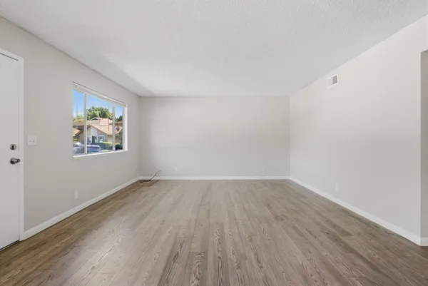 an empty room with wooden floor and window