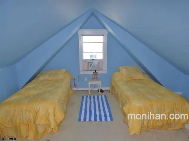 a view of a bedroom with wooden floor and a rug