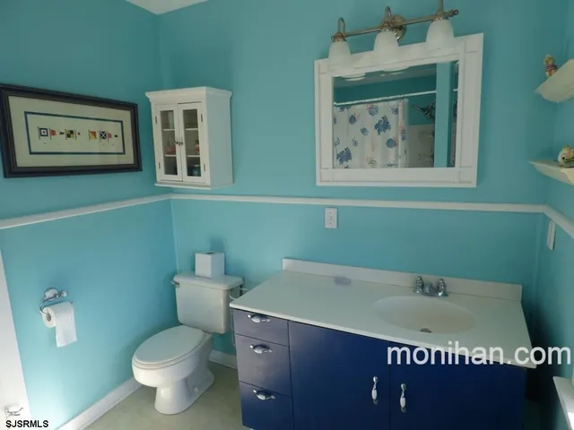 a bathroom with a toilet sink and mirror