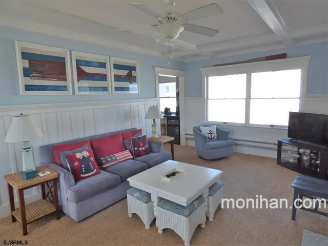 a living room with furniture a flat screen tv and a window