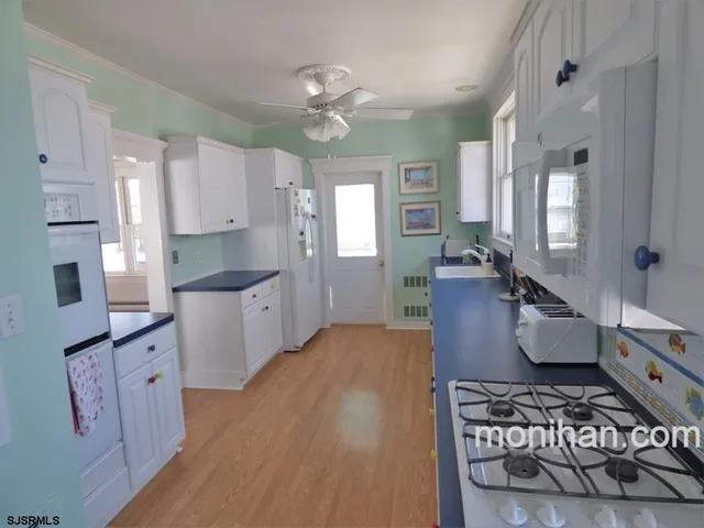 a large kitchen with a lot of cabinets and wooden floor