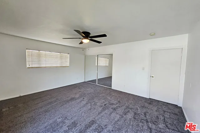 a view of a livingroom with a ceiling fan and window