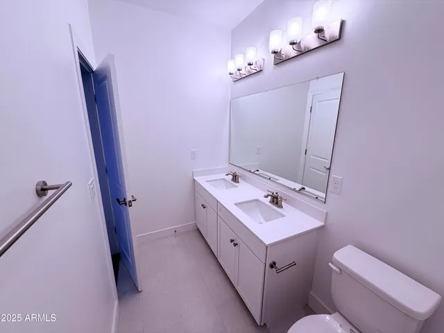 a bathroom with a double vanity sink toilet and shower
