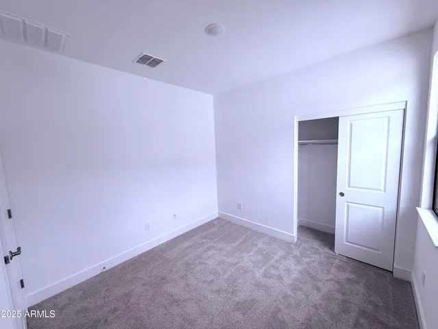 an empty room with windows and closet