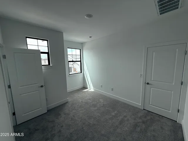 an empty room with windows and closet