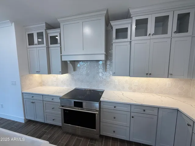 a kitchen with granite countertop white cabinets and stainless steel appliances