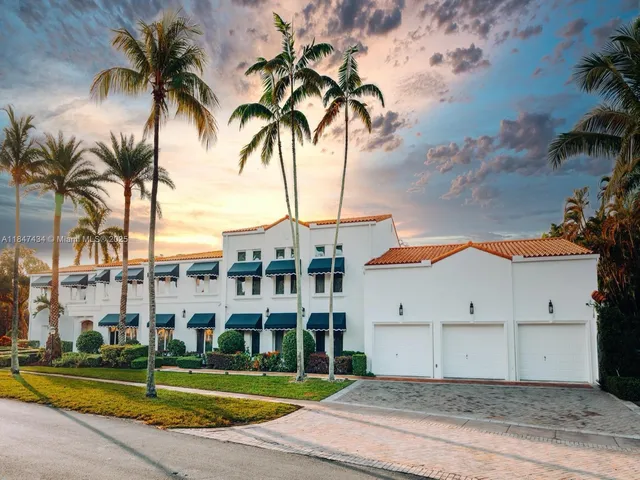 a view of a white building with a palm trees