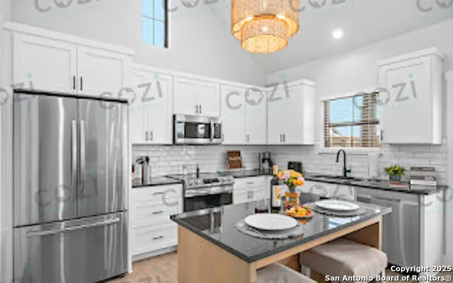 a kitchen with stainless steel appliances granite countertop a sink dishwasher a refrigerator and a stove with white countertops