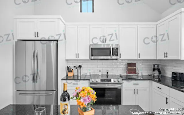 a kitchen with stainless steel appliances granite countertop a refrigerator sink and stove top oven