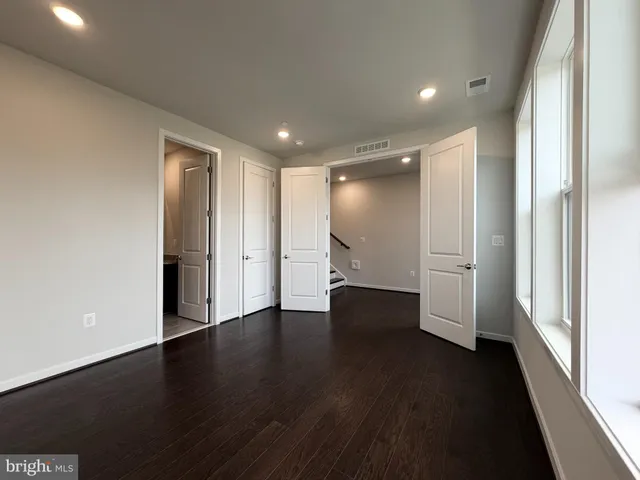 a view of empty room with wooden floor