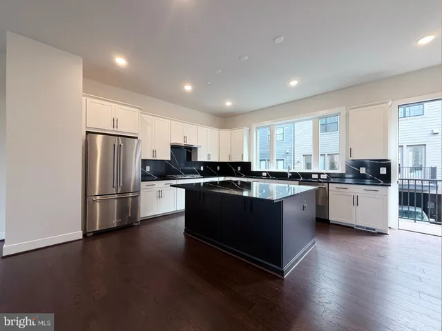 a kitchen with stainless steel appliances granite countertop a refrigerator and a stove top oven