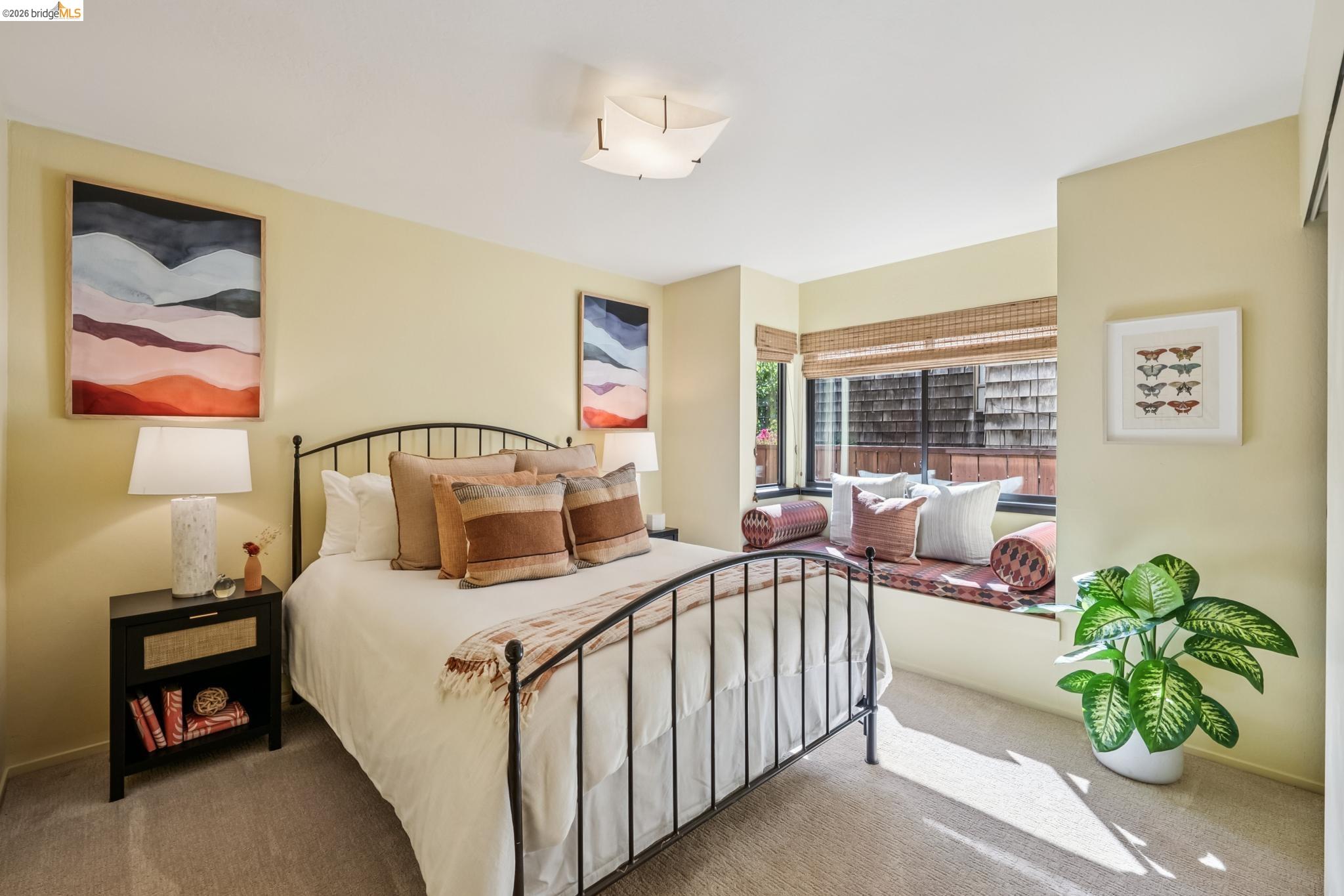 576 Vistamont Avenue Berkeley, CA 94708 - Photo 29 of 33 Carpeted bedroom featuring a black metal bed frame, built-in window seat, large window with bamboo blinds, and a built-in closet