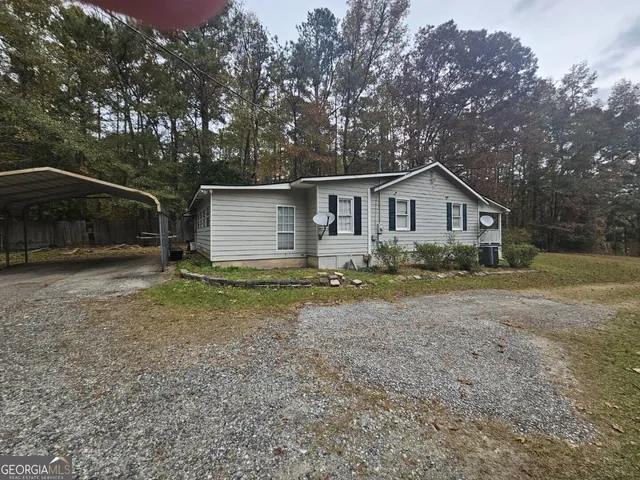 a view of a house with a yard and large tree