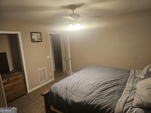 a bedroom with a bed and a flat tv screen on a dresser